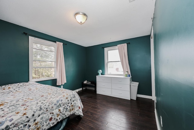 bedroom featuring baseboards and dark wood-style flooring