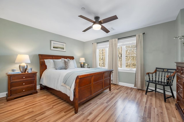 bedroom featuring light wood-style flooring, a ceiling fan, and baseboards