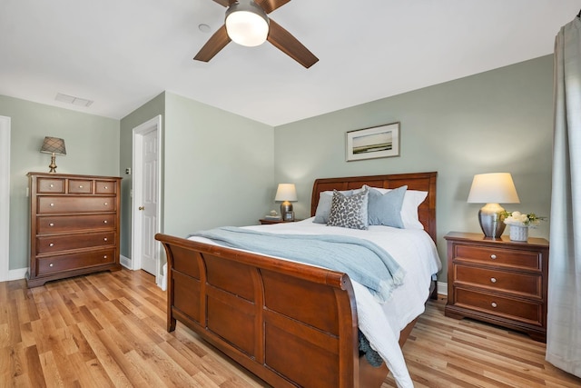 bedroom featuring light wood-type flooring, baseboards, visible vents, and ceiling fan