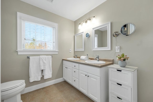 full bath with tile patterned flooring, toilet, baseboards, and a sink