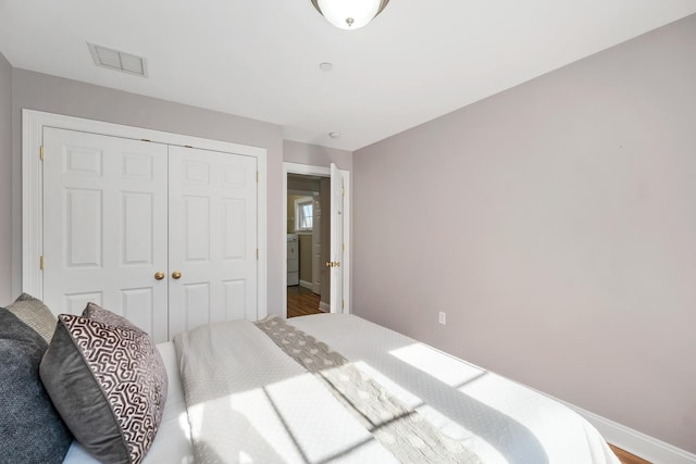 bedroom featuring a closet, visible vents, and baseboards