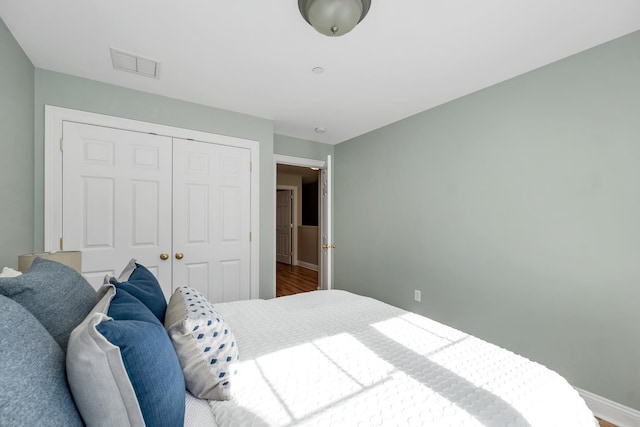 bedroom with visible vents, a closet, and baseboards