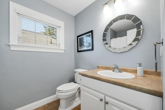 bathroom featuring baseboards, toilet, vanity, and tile patterned flooring