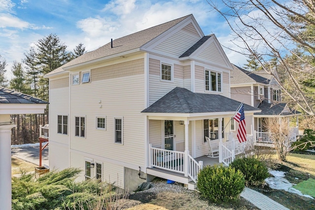 view of front of house featuring covered porch and a shingled roof