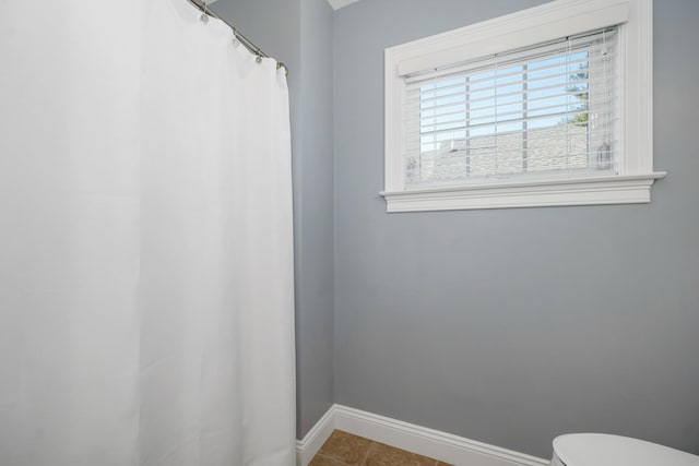 full bath featuring tile patterned flooring, toilet, a shower with shower curtain, and baseboards