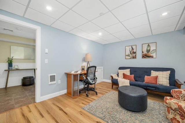 office featuring visible vents, a paneled ceiling, and wood finished floors