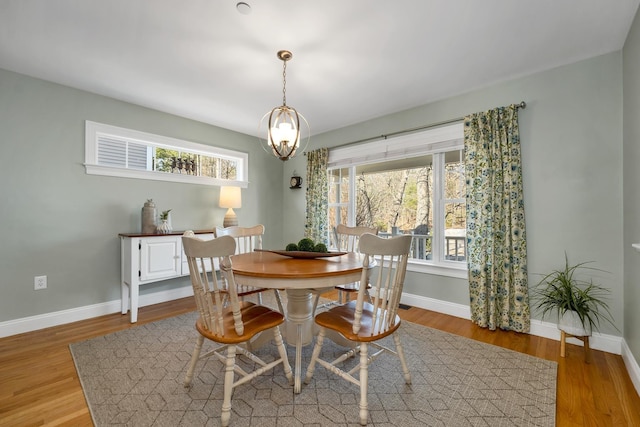 dining area with baseboards and wood finished floors