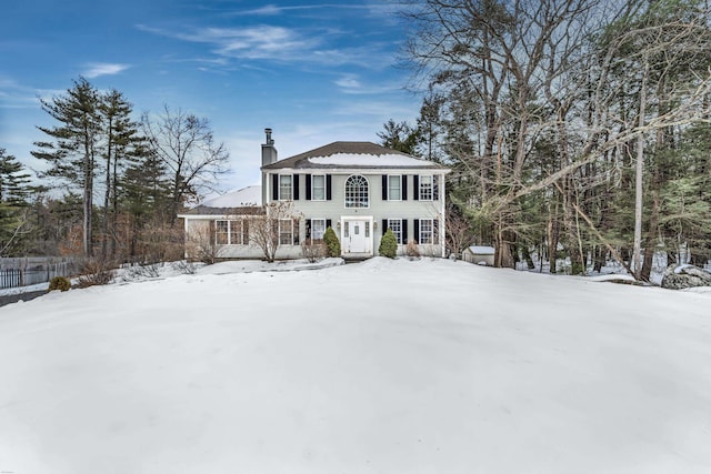 view of front of home with a chimney and fence