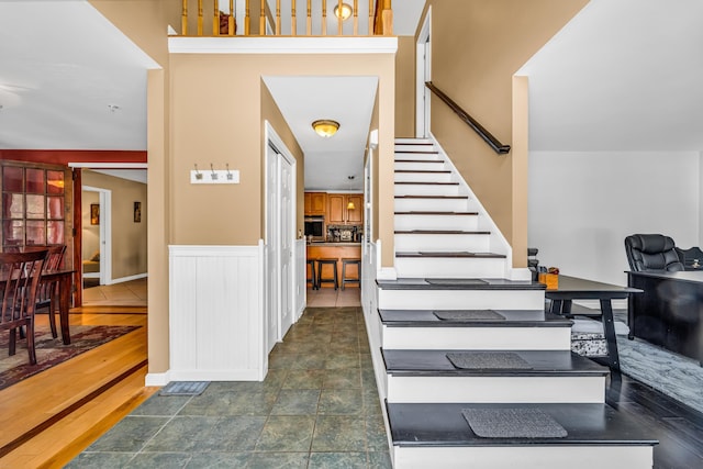 stairs with a wainscoted wall