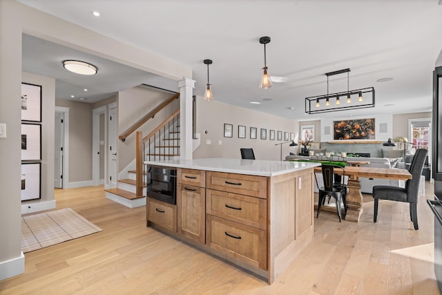 kitchen with open floor plan, light wood finished floors, and pendant lighting