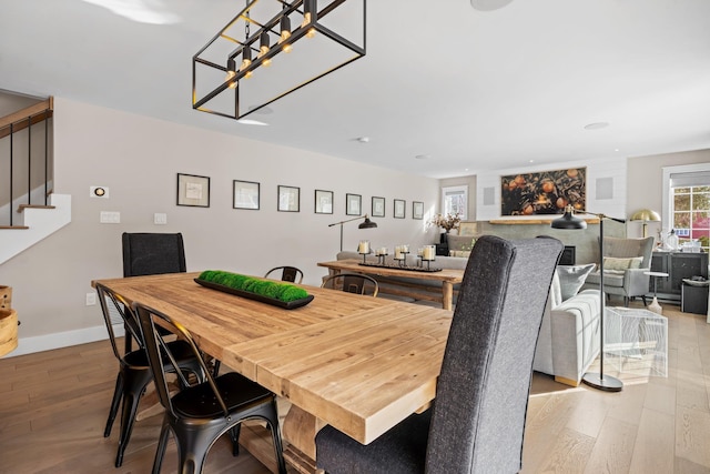 dining space featuring recessed lighting, baseboards, wood finished floors, and stairs