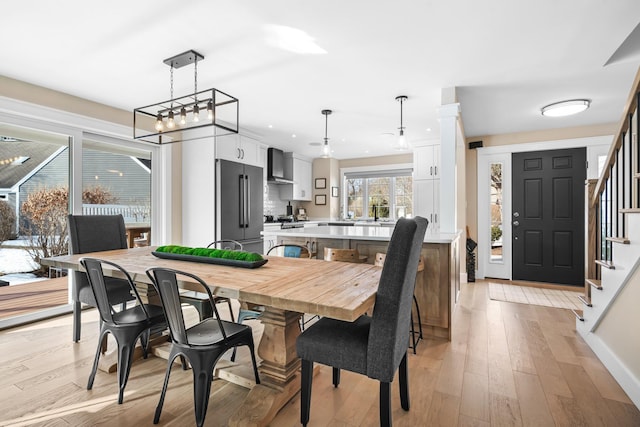 dining space with light wood finished floors, recessed lighting, and stairs