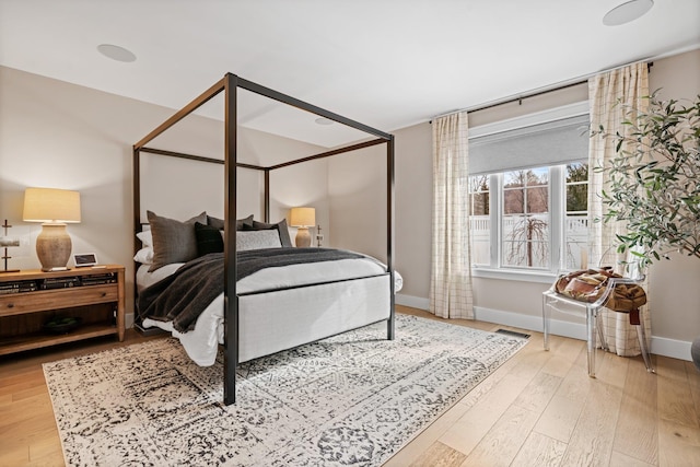 bedroom featuring visible vents, baseboards, and wood finished floors