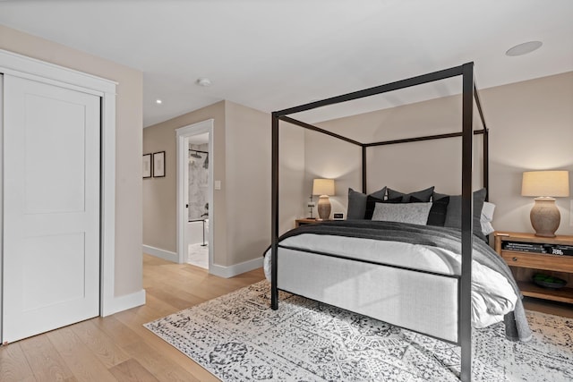 bedroom featuring light wood finished floors and baseboards