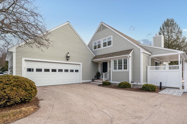 view of front of home with a garage, roof with shingles, a chimney, and driveway