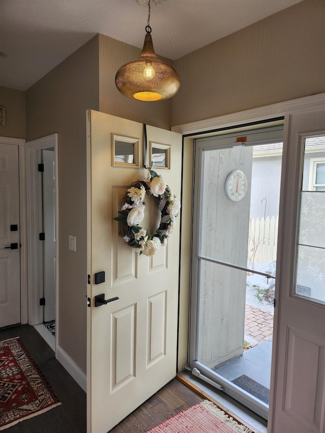 entryway featuring dark wood-type flooring and baseboards