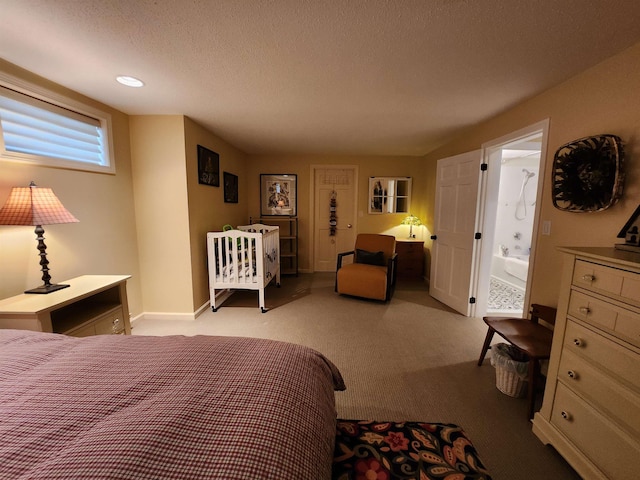 bedroom with baseboards, carpet, ensuite bathroom, and a textured ceiling