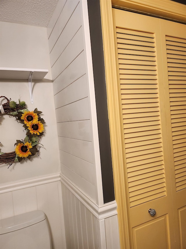 interior details featuring wainscoting and a textured ceiling