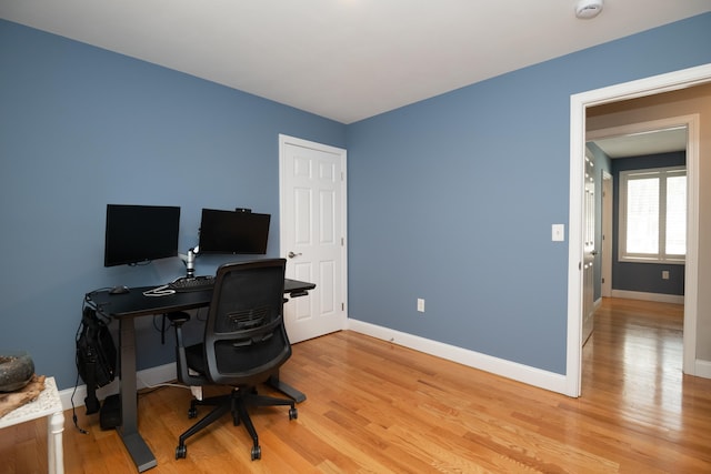 home office with baseboards and light wood-style floors