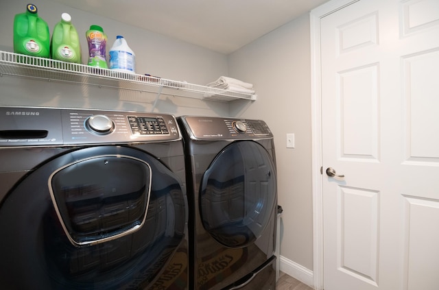 laundry area featuring baseboards, separate washer and dryer, and laundry area