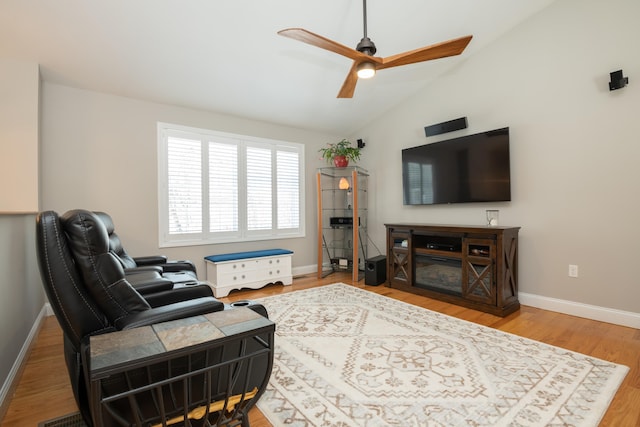 living room featuring a ceiling fan, lofted ceiling, wood finished floors, and baseboards