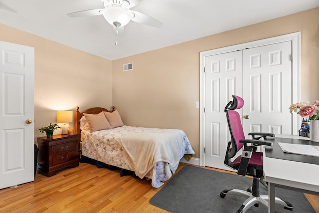 bedroom featuring visible vents, light wood-style floors, a closet, and ceiling fan