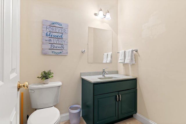 half bath with toilet, vanity, and baseboards