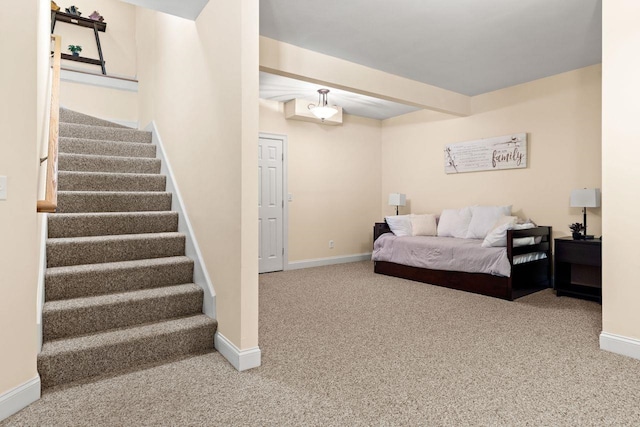 carpeted bedroom featuring beamed ceiling and baseboards