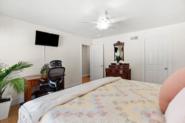 bedroom with visible vents, a ceiling fan, baseboards, and wood finished floors