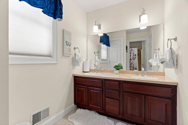 full bathroom with a sink, visible vents, baseboards, and double vanity