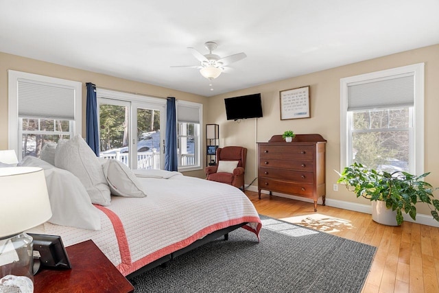 bedroom with multiple windows, baseboards, and light wood-style floors