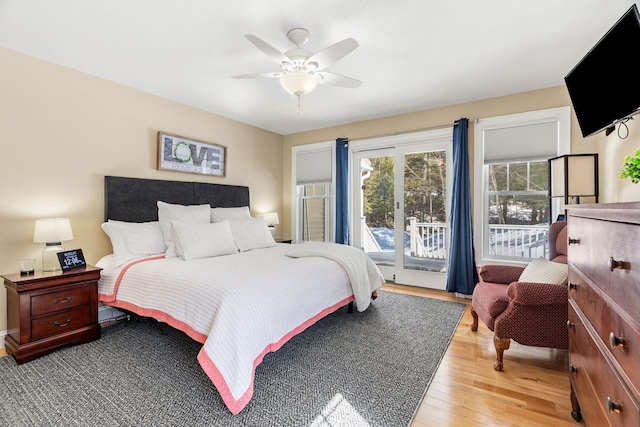 bedroom with a ceiling fan, access to outside, and wood finished floors