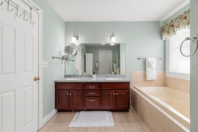 full bathroom featuring a garden tub, double vanity, tile patterned floors, and a sink