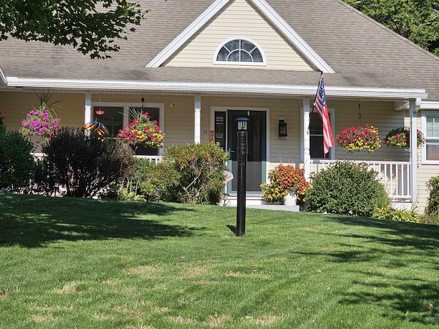 farmhouse-style home featuring roof with shingles, covered porch, and a front lawn