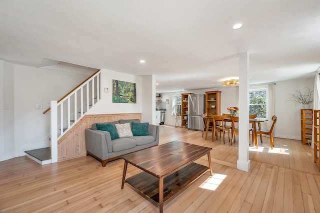 living area with recessed lighting, stairway, baseboards, and light wood finished floors