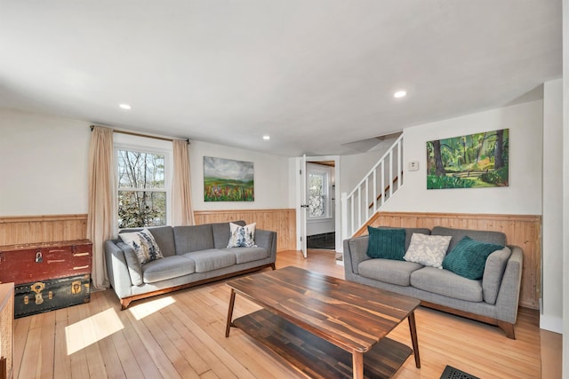 living room with stairway, wainscoting, and wood-type flooring