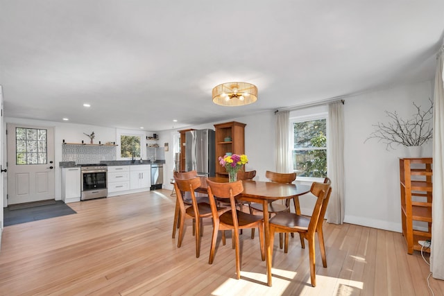 dining space with recessed lighting, baseboards, and light wood-style floors