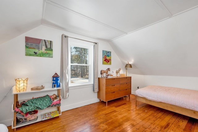 bedroom featuring hardwood / wood-style flooring, baseboards, and vaulted ceiling