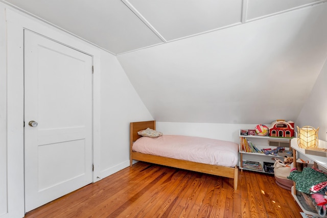 bedroom featuring vaulted ceiling and wood finished floors