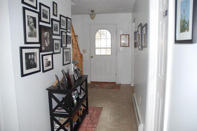 doorway featuring tile patterned floors, baseboard heating, stairs, and baseboards