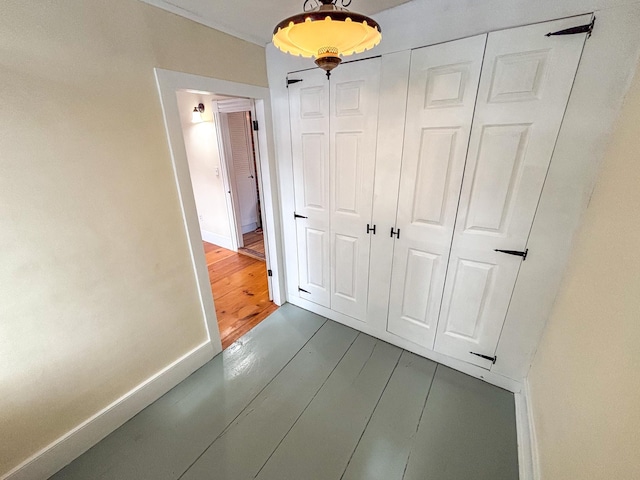 hall featuring wood finished floors and baseboards