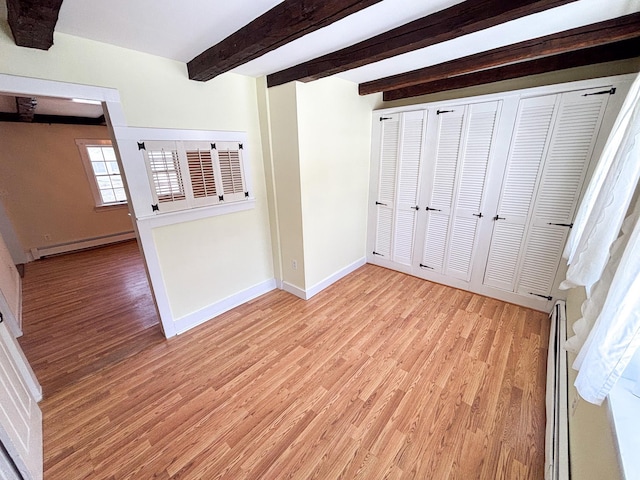 unfurnished bedroom with beam ceiling, light wood-style floors, baseboards, and a baseboard radiator