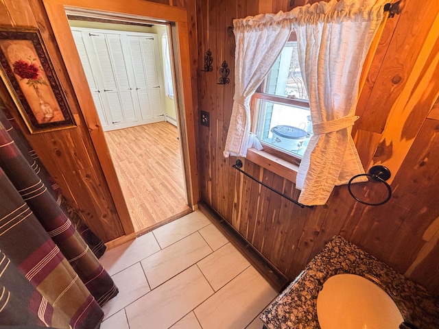 entryway with wood walls and a baseboard radiator