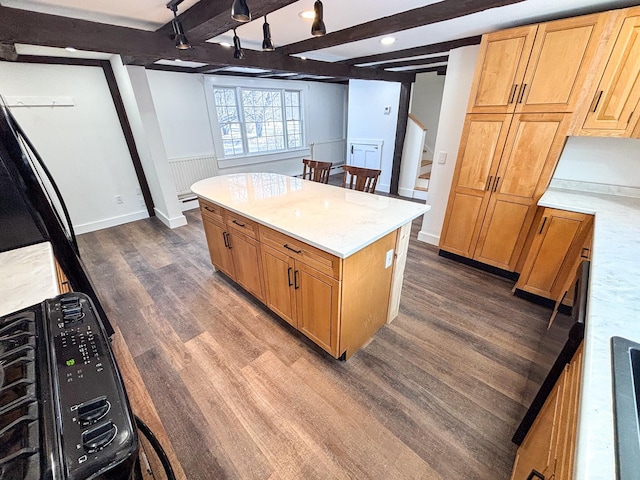 kitchen featuring light stone countertops, a wainscoted wall, dark wood-style flooring, beamed ceiling, and a center island