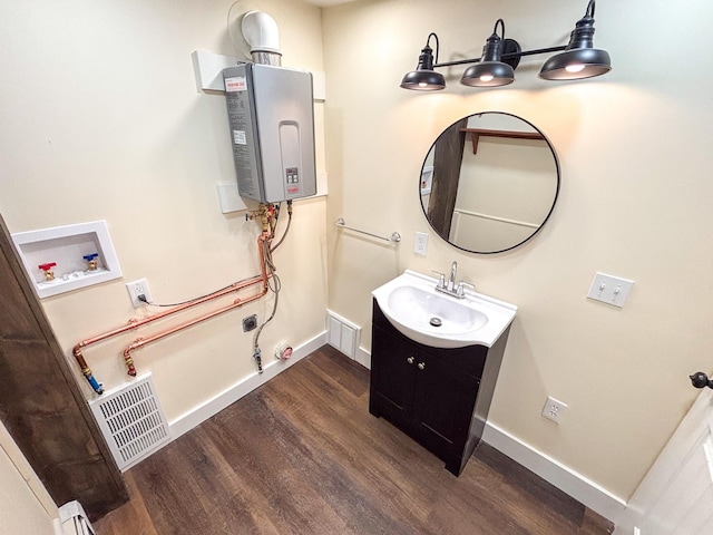 bathroom featuring water heater, visible vents, baseboards, and wood finished floors