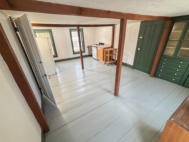 basement featuring baseboards and light wood-style floors