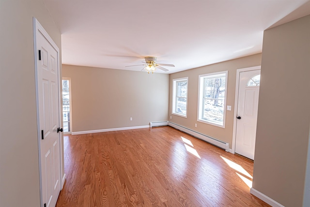 foyer with light wood-style flooring, baseboards, a wealth of natural light, and a baseboard radiator