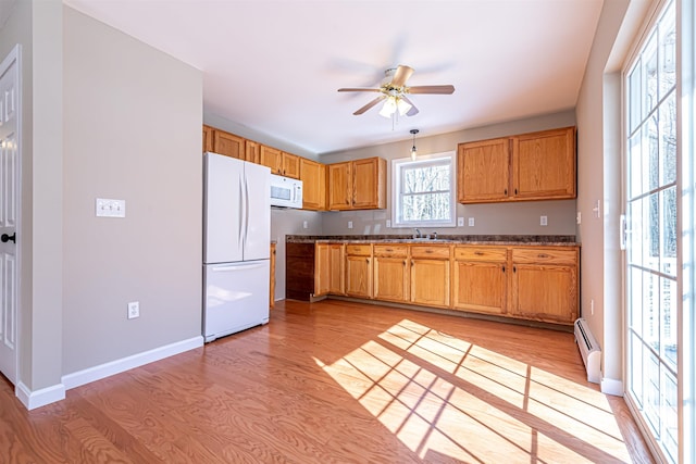 kitchen with white appliances, baseboards, light wood finished floors, a baseboard radiator, and ceiling fan