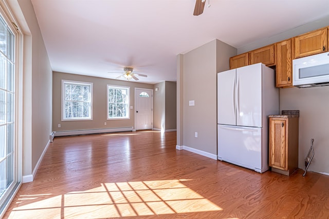 kitchen featuring light wood-type flooring, white appliances, baseboards, baseboard heating, and ceiling fan