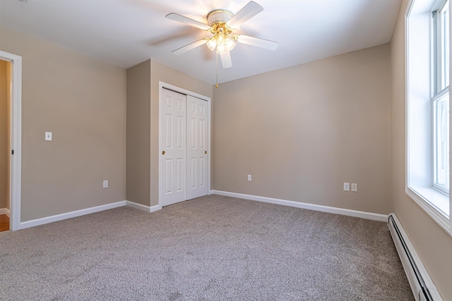 unfurnished bedroom featuring baseboards, carpet flooring, a closet, a ceiling fan, and a baseboard radiator